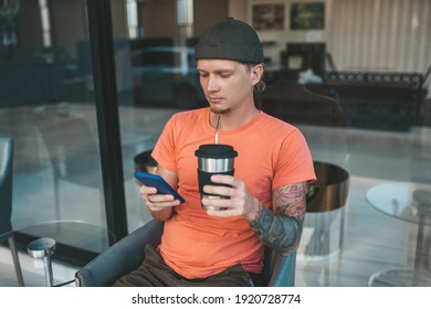 Man In Orange T-shirt Drinking Coffee From Reusable Coffee Cup