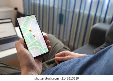 Man Ordering A Taxi Online With His Mobile Device, Showing The App Interface On His Phone And Selecting The Location On A Map Of The City. Man Examining Nearby Taxi On Map In His Taxi Mobile App.