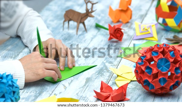 折り紙の折り方を教える人 木のテーブルの上に美しい折り紙のフィギュアを集めたコレクション 伝統的な折り紙 の写真素材 今すぐ編集