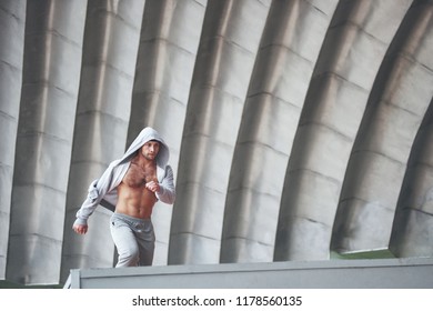The man outdoors practices parkour, extreme acrobatics - Powered by Shutterstock