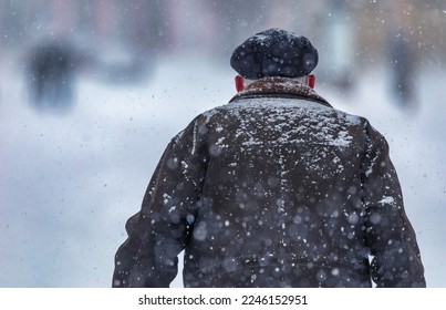 Man outdoors in winter clothes during blizzard and heavy snowfall. Deterioration of weather conditions. concept - Shutterstock ID 2246152951