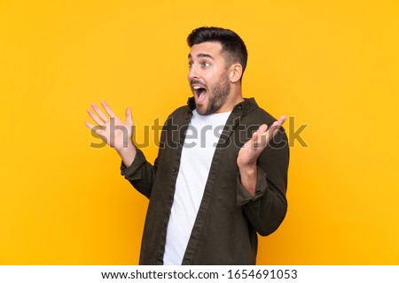 Man over isolated yellow background with surprise facial expression