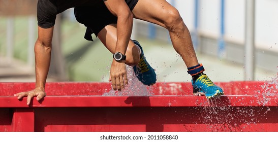 Man overcomes water obstacle on obstacle course. Mud race runners - Powered by Shutterstock