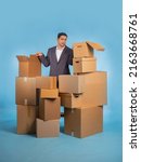 Man Overjob. Human in jacket among boxes. Business owner wearily opens box. Dark haired guy Overjob. Concept businessman upset because of overworking. Unhappy Indian businessman. Fatigue at work