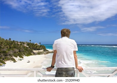 Man Overlooking Beach From Balcony