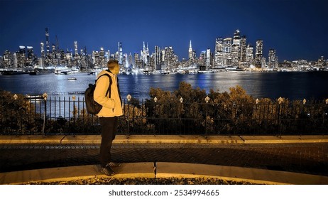 Man Overlooking City Skyline at Night. A man stands on a sidewalk, gazing at a stunning nighttime city skyline across the water. - Powered by Shutterstock