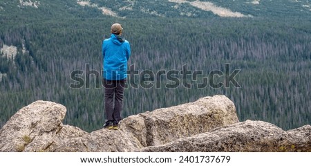 Man Overlooks Rocky Mountain Wilderness from Stormy Peaks  in Rocky Mountain National Park