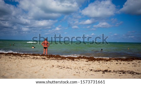 Man overseeing the ocean in a Speedo