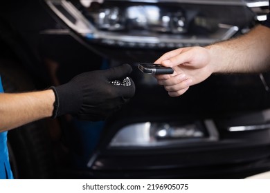 Man Owner Of The Auto Gives The Keys To The Car Repairman. Vehicle Breaks Down. Close Up Shot Of Hands Of Male Client Giving Car Key To Mechanic In Auto Repair Shop. Car Repair.