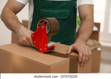 Man Packing Box With Adhesive Tape Indoors, Closeup. Moving Service