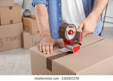 Man packing cardboard box indoors, closeup. Moving day - Shutterstock ID 1181851378