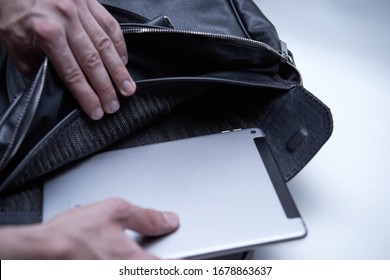 Man Is Packing His Laptop In Black Leather Bag. Person Is Getting Tablet From Men's Briefcase For Travel Office Business. Useful Bag For Trip. Spacious Traveling Bag