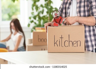 Man packing moving box indoors, closeup. Space for text - Shutterstock ID 1180314025