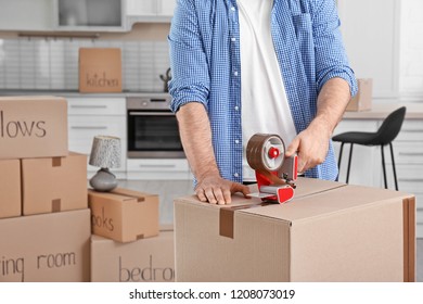 Man packing moving box indoors, closeup. Space for text - Shutterstock ID 1208073019