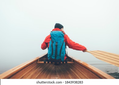 Man Paddling Canoe In The Winter	