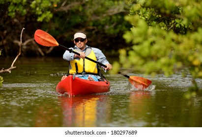 Man Paddling In A Red Kayak In Florida
