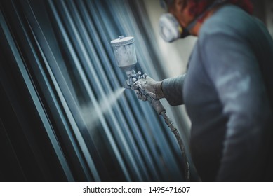 Man Painting Metal Products With A Spray Gun