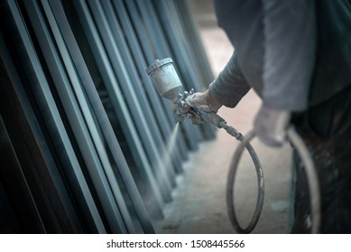 Man Painting Metal Products With A Spray Gun