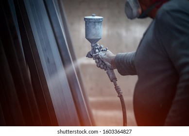 Man Painting Metal Products With A Spray Gun