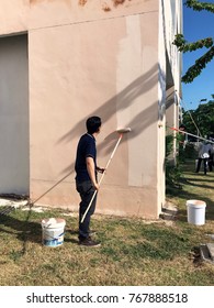 Man Painting New Color On The Wall Exterior Of Building Repair And Renovation Concept. 