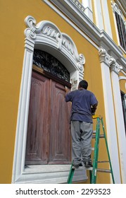 Man Painting Old House