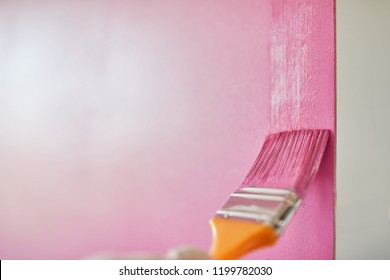 Man Painting The Wall With Paint Brush