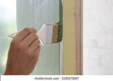 Man Painting A Wall With A Paintbrush With Green Color, DIY House Improvement Project	