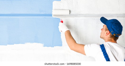 Man painting wall with roller. Builder worker painting walls with white color. Wide banner, copy space for text.