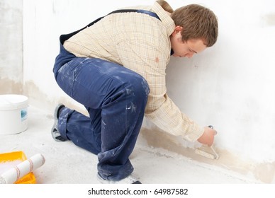 Man Painting Wall With Small Roller