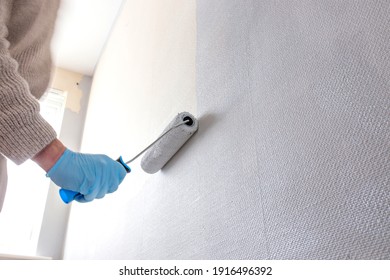 Man Painting Wall Using A Paint Roller. Do It Yourself Concept