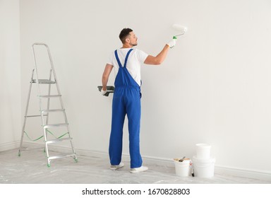 Man Painting Wall With White Dye Indoors