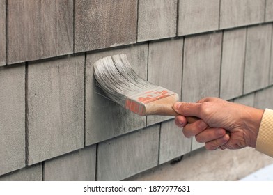 Man Painting Wooden House Exterior Wall With Paintbrush. DIY. COVID Project.