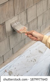 Man Painting Wooden House Exterior Wall With Paintbrush. DIY. COVID Project.