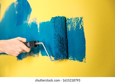 Man Painting Yellow Wall With Blue Dye, Closeup