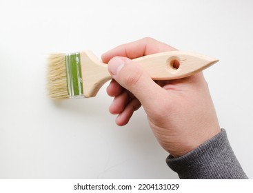 Man Paints The Surface With A Brush. Hand With A Brush. Master DIY Home Repair.