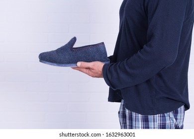 Man With Pajamas And House Slippers In Hands