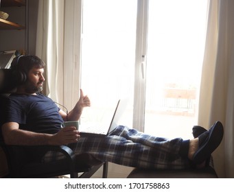 Man In Pajamas With Laptop Working On Sofa At Home. Working At Home
