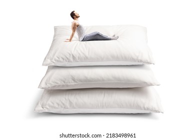 Man In Pajamas Stretching On A Pile Of Pillows Isolated On White Background