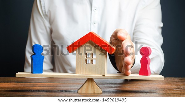 A man with a palm separates the house from the wife\
in favor of the husband. Property separation, real estate division\
after divorce, lawyer services. trial of ownership of the house,\
illegal owner