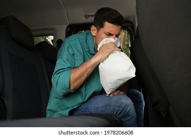 Man With Paper Bag Suffering From Nausea In Car