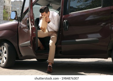 Man With Paper Bag Suffering From Nausea In Car