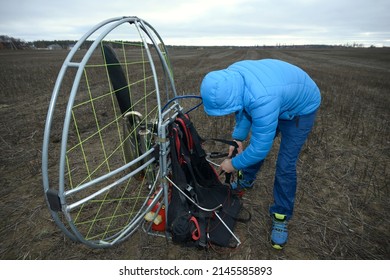 Man paramotorist preparing the paramotor for flight. January 12, 2020. Kiev, Ukraine