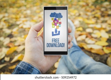 Man In The Park With Free Download Smartphone. All Screen Graphics Are Made Up.