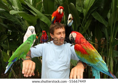 Man with parrots sitting on the shoulder and head