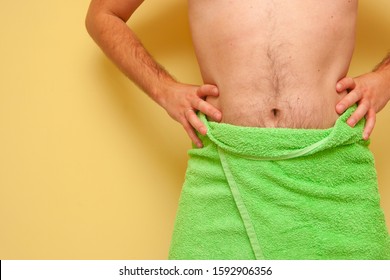 Man (part Of Man) With The Green Towel Around His Waist. Isolated On Yellow.