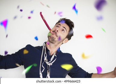 Man With A Party Horn Blower And Confetti Pieces 
