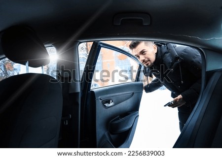 A man passenger gets into a taxi on a city street in winter. Inside view of a taxi car. Transportation, Services