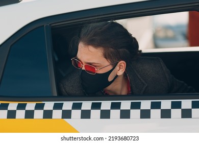 Man Passenger In Protective Face Medical Mask In The Taxi Car During An Epidemic Quarantine City. Health Protection, Safety And Pandemic Covid-19