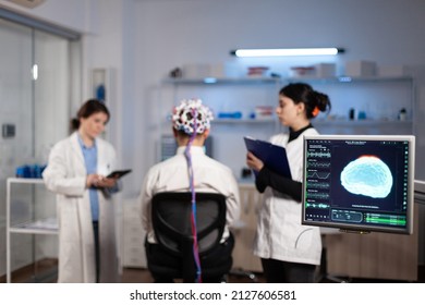 Man Patient With Eeg Headset For Brain Scan Standing In Neurological Laboratory During Neurology Experiment. Medical Team Of Scientist Monitoring Brain Activity Analyzing Nervous System