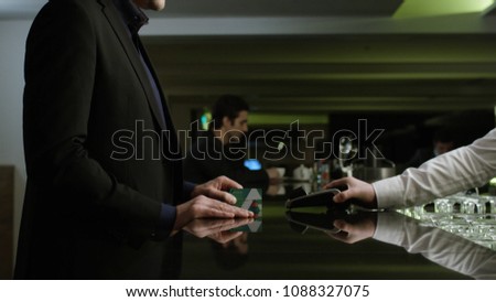 Man paying the bill. Stock. Businessman pays the bill by card at the restaurant